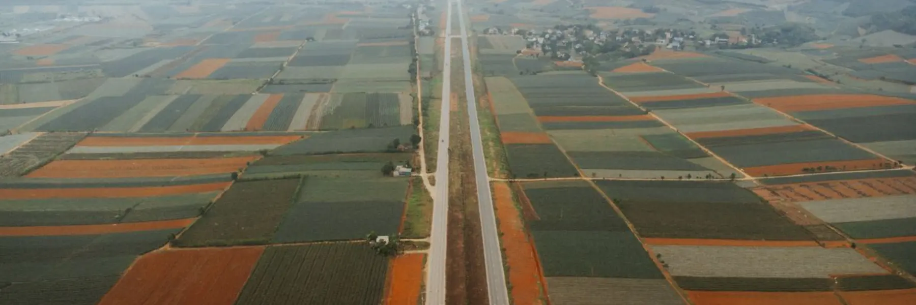 Vista aérea de uma estrada reta cortando lavouras